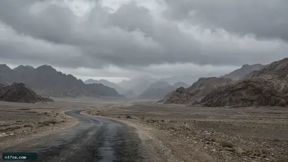 طريق صحراوي مبلل تحت سحب رمادية فوق تلال سيناء الصخرية
